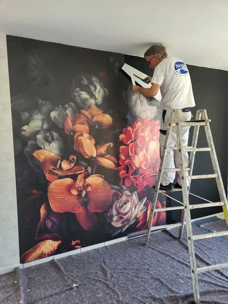 Malermeister beim Aufbringen einer großformatigen Blumentapete