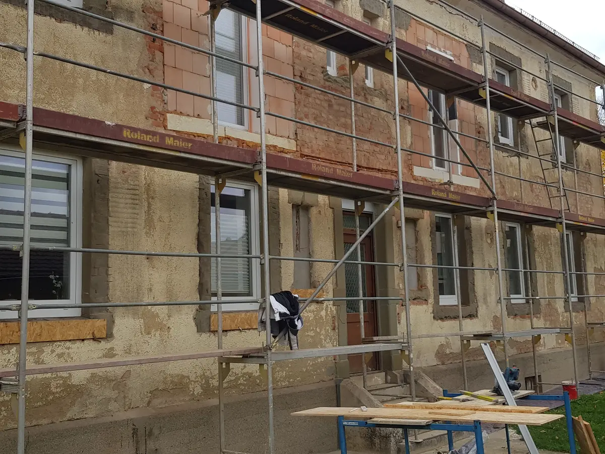 Baugerüst mit „Roland Maier"-Branding rund um eine Fassade in Sanierung