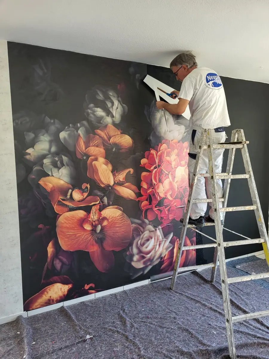 Malermeister beim Aufbringen einer großformatigen Blumentapete